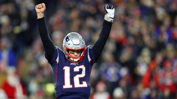 Former New England Patriots quarterback Tom Brady celebrates in the middle of a game.